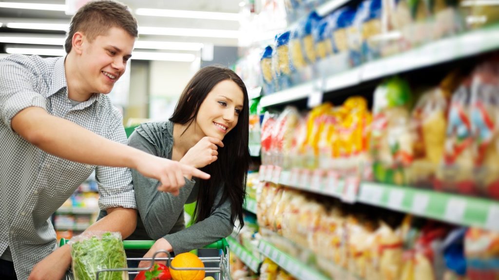 Pareja de jóvenes seleccionando alimentos.