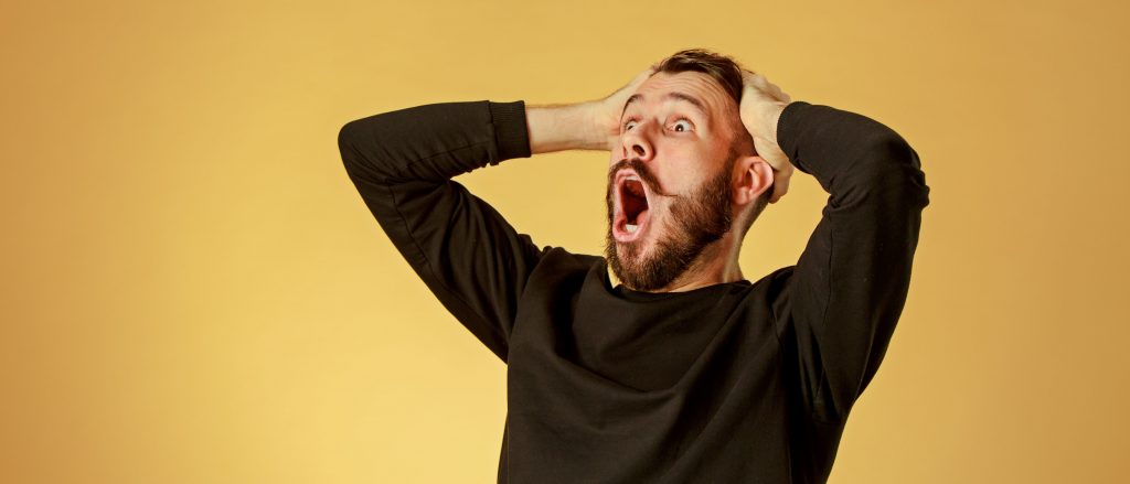 Hombre adulto sorprendido y con manos a la cabeza