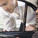 persona dentro de un auto hablando con otra fuera del auto
