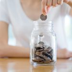 mujer depositando una moneda en un recipiente