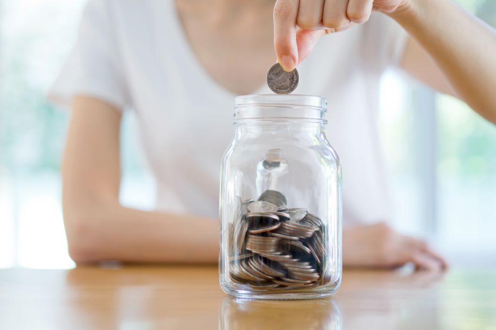 mujer depositando una moneda en un recipiente