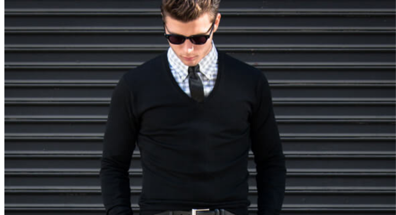 Hombre con camisa abotonada y suéter.